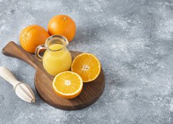 Dzbanek z sokiem i pomarańcze na desce