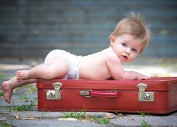 Dziecko w pampersie na walizce