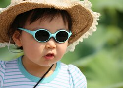 Dziecko w słomkowym kapeluszu i okularach słonecznych