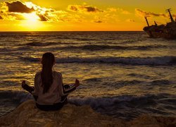 Dziewczyna siedząca nad brzegiem morza