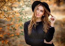 Dziewczyna w kapeluszu w jesiennej scenerii