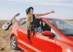 Dziewczyna z gitarą w samochodzie