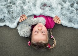 Dziewczynka przykryta pianą morską