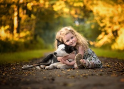 Dziewczynka przytulona do psa