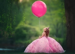 Dziewczynka w balowej sukience z balonikiem na wstążce