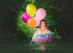 Dziewczynka w kolorowej sukience z balonami