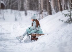 Dziewczynka w łyżwach na ławeczce