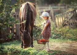 Dziewczynka z koszykiem obok konia