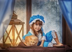 Dziewczynka z kotem obok lampionu