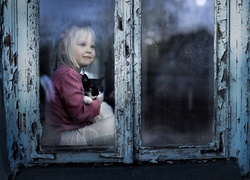 Dziewczynka z kotem siedząca przy starym oknie