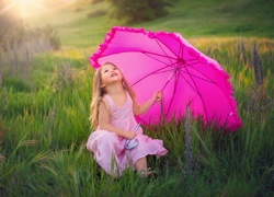 Dziewczynka z różowym parasolem na łące