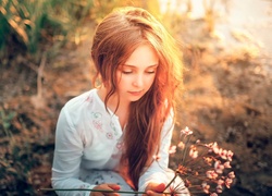 Dziewczynka z suchym kwiatkiem w dłoni