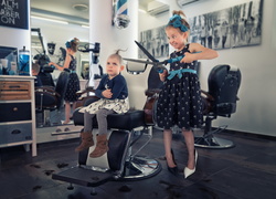 Dziewczynka z wielkimi nożycami w śmiesznej scenie w zakładzie fryzjerskim