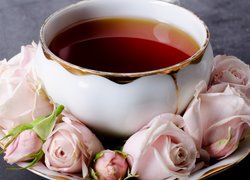 Filiżanka herbaty na spodku z różami