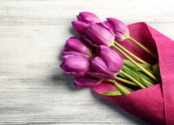 Fioletowe tulipany w bibule na deskach