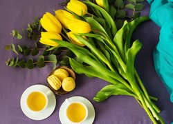 Herbata z ciasteczkami obok żółtych tulipanów