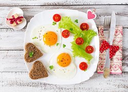 Jajka sadzone i chleb w kształcie serca na talerzu
