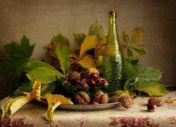 Jesienna kompozycja z kasztanami, liśćmi i butelką