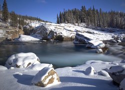 Kamienie nad rzeką przysypane śniegiem