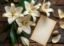 Kartka obok białych lilii na deskach