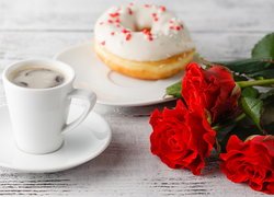 Kawa i pączek obok róż