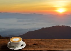 Kawa w filiżance i widok na zachodzące słońce