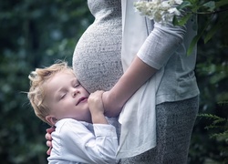 Kobieta w ciąży i chłopiec przytulony do niej