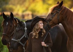 Kobieta w kapeluszu i trzy konie