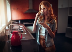 Kobieta w kuchni pije poranną kawę