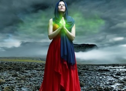 Kobieta w pozie modlitewnej ze złożonymi dłońmi w chuście na głowie