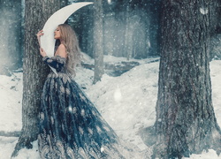 Kobieta w zaśnieżonym lesie z księżycem w rękach