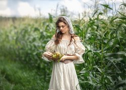 Kobieta z koszyczkiem na polu kukurydzy