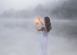 Kobieta z lampką w welonie mgły