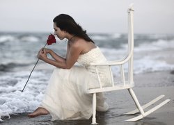 Kobieta z różą na krześle