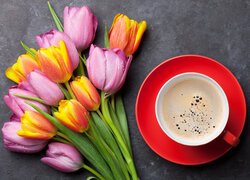 Kolorowy bukiet tulipanów obok filiżanki kawy