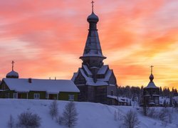 Kolorowy zachód słońca nad kościołem w zimowej scenerii