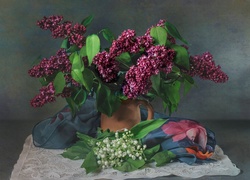 Kompozycja kwiatowa z bzem w wazonie i bukiecikiem konwalii na szalu