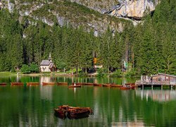 Kościół pod lasem i łodzie na jeziorze Lago di Braies