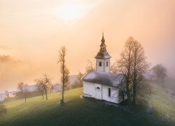 Kościół św Primusa i Felicjana we wsi Jamnik na tle mgły nad górami