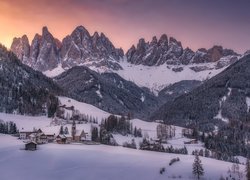 Kościół we wsi Santa Maddalena na tle ośnieżonych Dolomitów