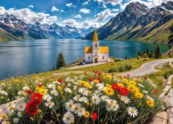 Kwiaty przy drodze i kościółek nad jeziorem w górach