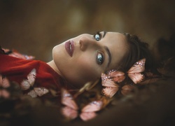 Leżąca kobieta otoczona motylami