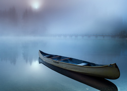 Łódka na zamglonym jeziorze Emerald Lake w Kanadzie