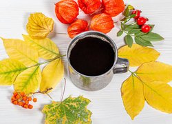 Miechunka i liście obok kubka z kawą