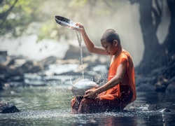 Młody mnich podczas rytuału nad rzeką