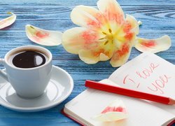 Notes z napisem I love you obok kawy i tulipana