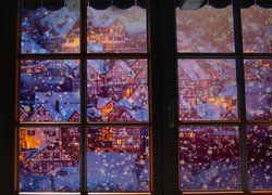 Okno z widokiem na ośnieżone domy w grafice