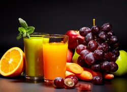 Owoce i marchew obok soku w szklankach