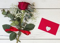Róża obok czerwonej koperty z serduszkiem