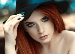 Rudowłosa niebieskooka kobieta w kapeluszu